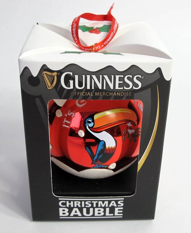 Rote Guinness Weihnachtskugel mit Toucan und Stechpalme